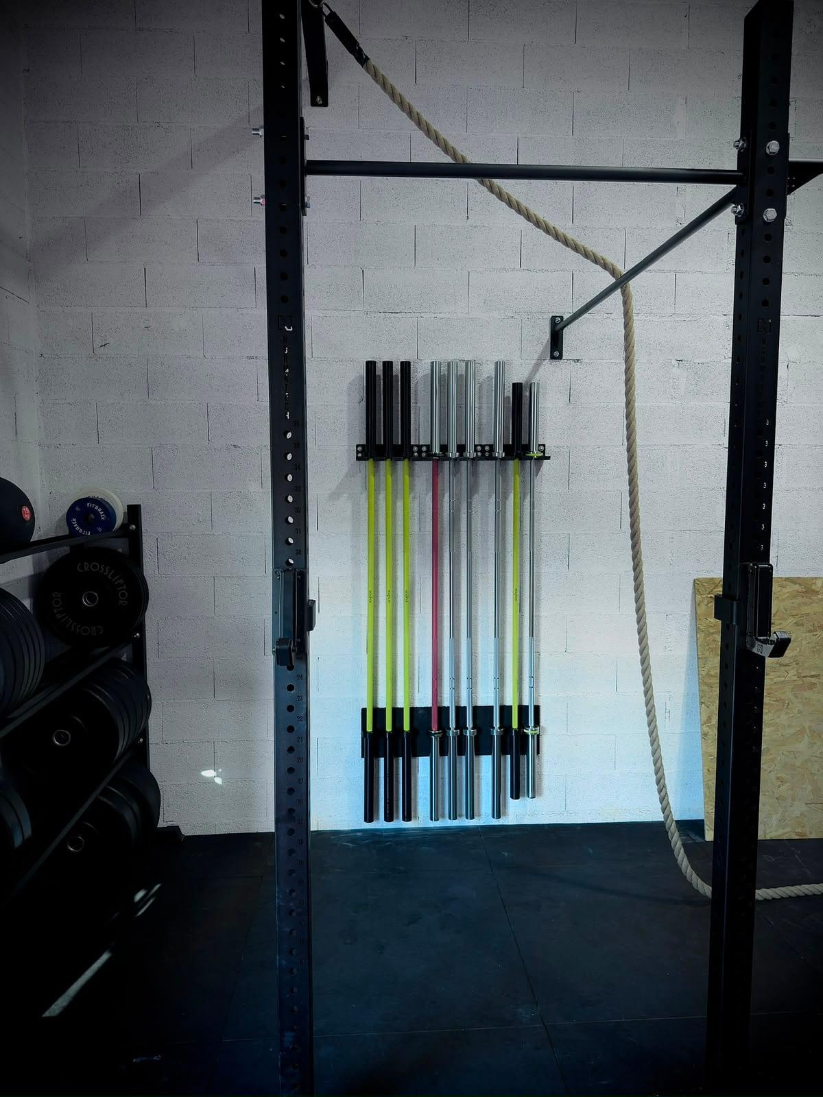 Rack de barres olympiques et corde ondulatoire dans l'espace de musculation