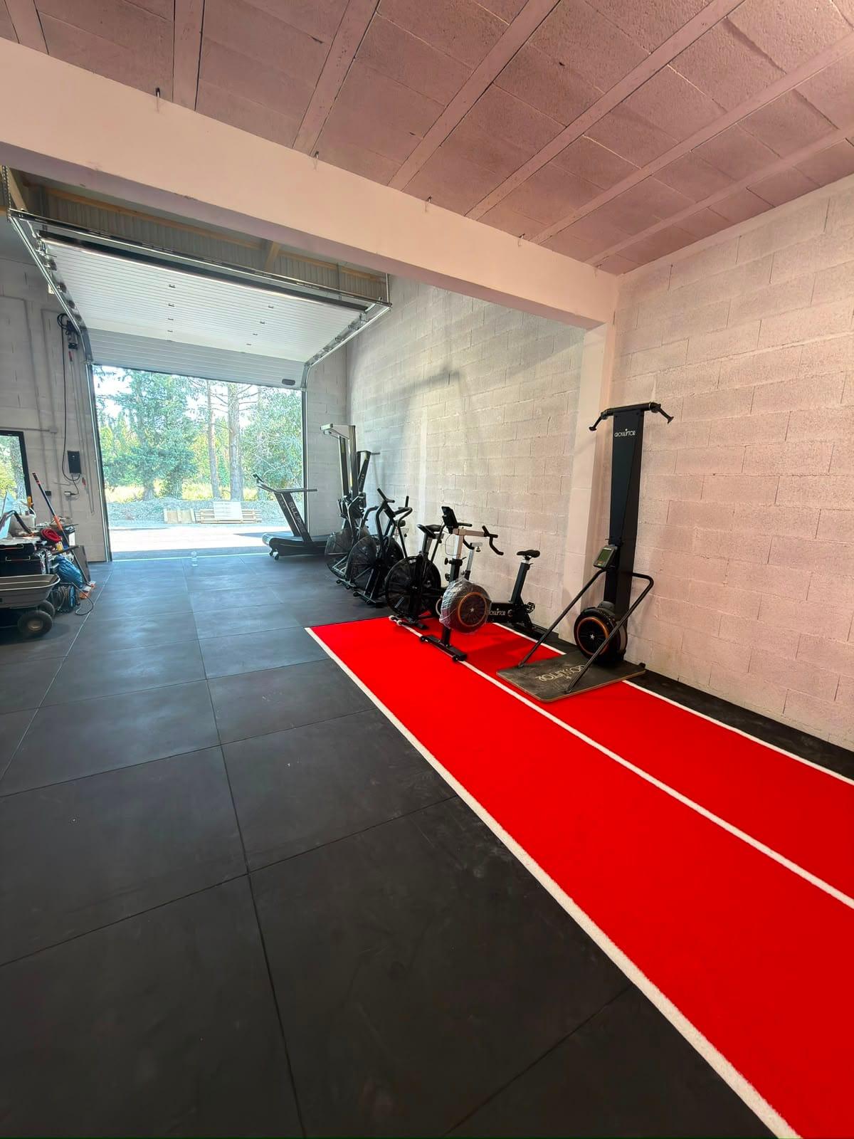 Zone cardio et piste de sprint face à la porte d'accès extérieure